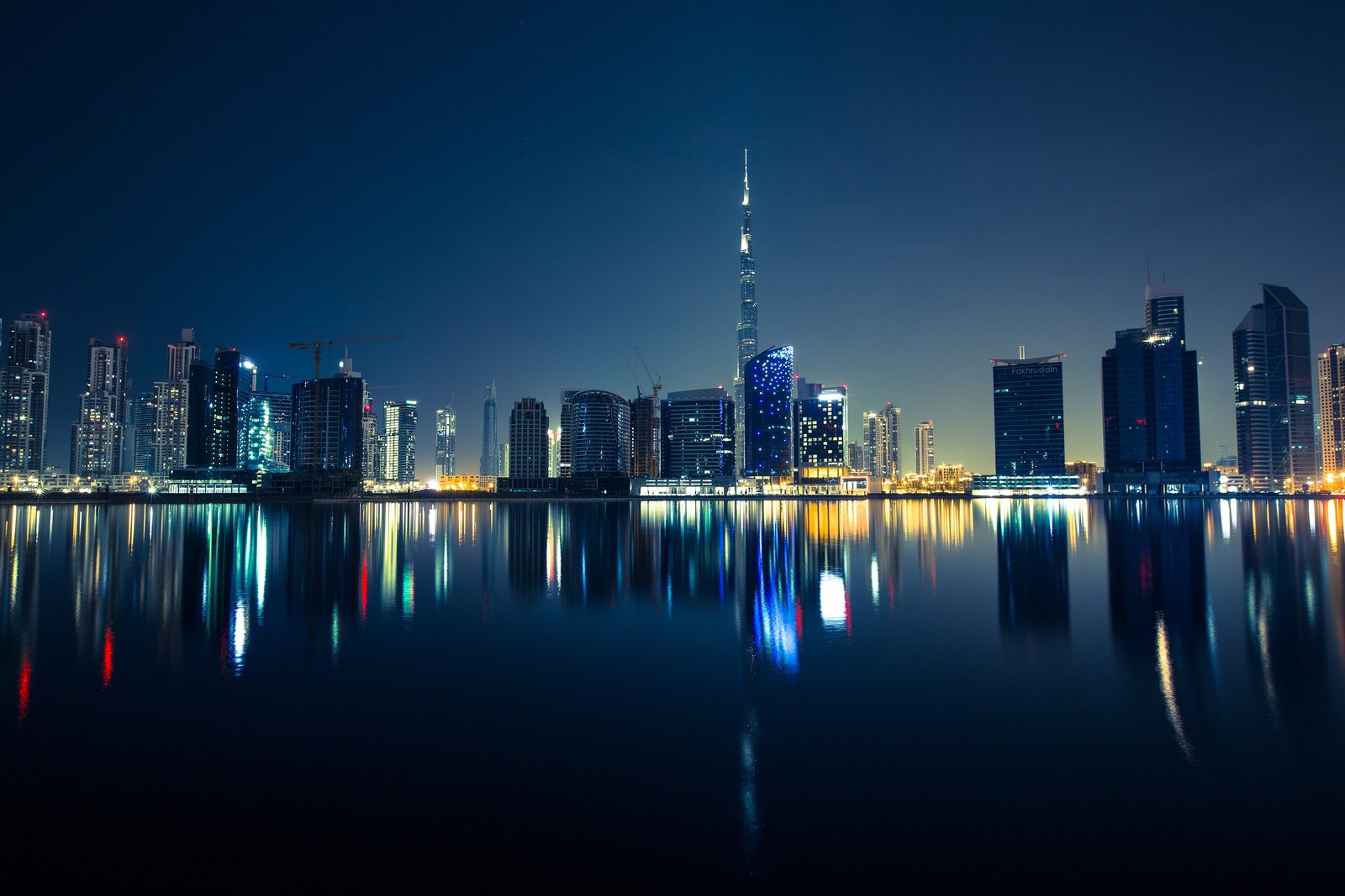 Downtown Dubai skyline and the Burj Khalifa reflected in the water at dusk