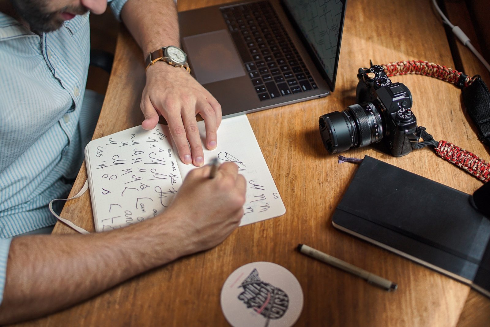 Sketching a system plan beside a laptop